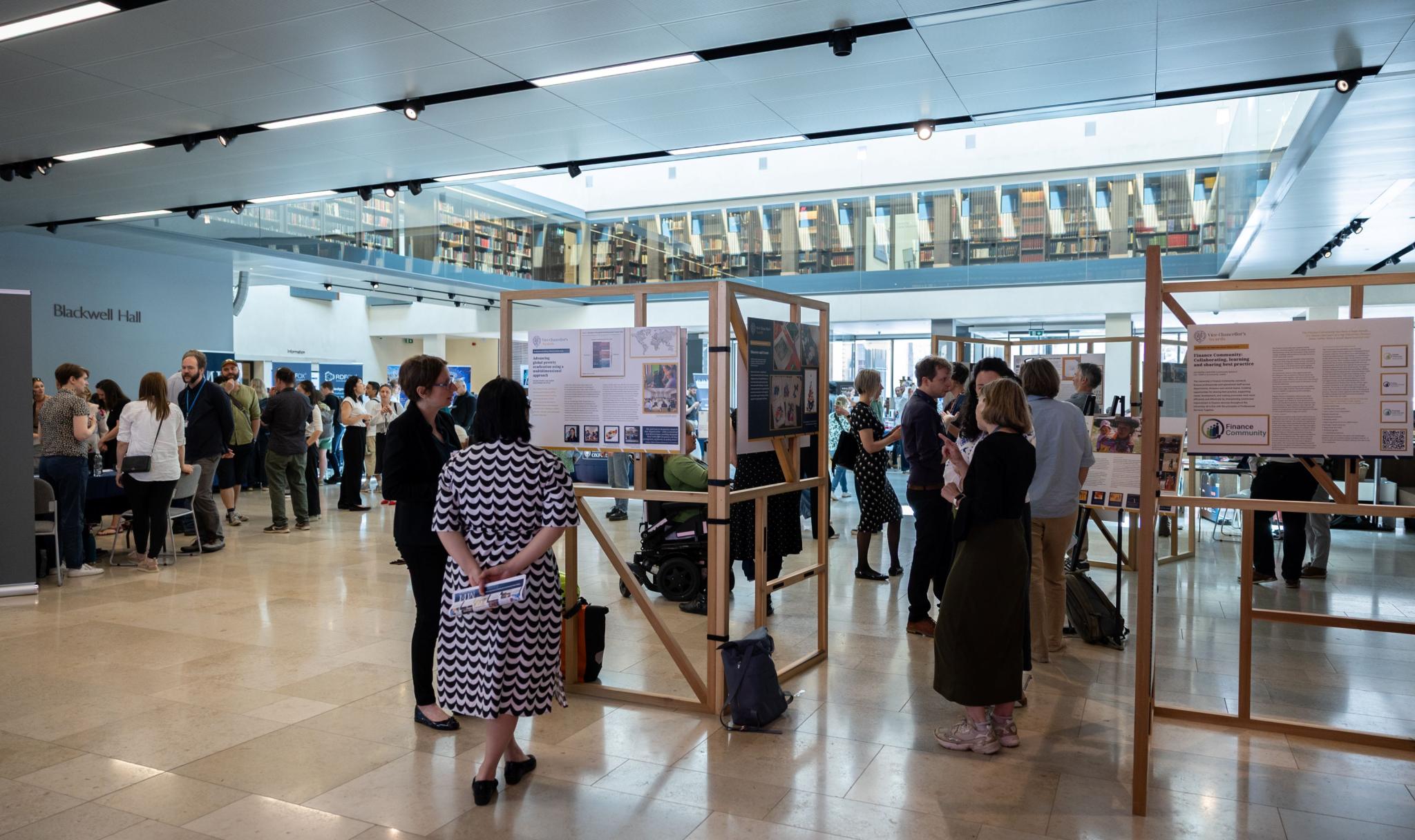 OPHI colleague discussing OPHI's work with a university colleague by an exhibition stand