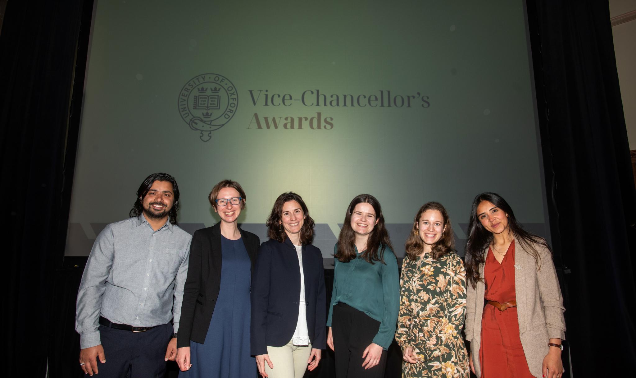 Members of the OPHI team in front of Vice-Chancellor Awards sign